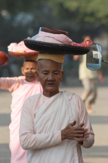 Monks are going through the village each morning. They are gathering the rice for the whole day. Nyaung U. Myanmar (Burma).
